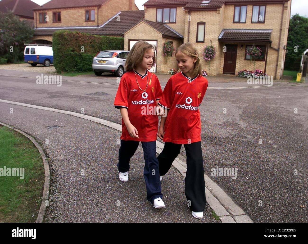 Zwei Kinderdarsteller, die Jessica Chapman, Left, und Holly Wells spielen, verlassen Holly Wells House (hinten mit blauem weißen Van) in Redhouse Gardens, während sie an einem Polizeirekonstruktion in Soham, Cambridgeshire, teilnehmen. * der Wiederaufbau folgt den letzten bekannten Bewegungen der zehn-Jährigen, die vermisst wurden, und löste eine riesige Suchkampagne aus. Stockfoto