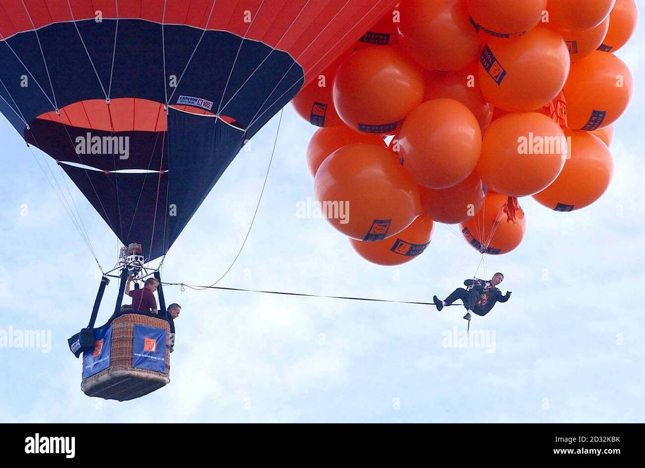 Mike Howard baumelt bei der Bristol Balloon Fiesta unter Hunderten von mit Helium gefüllten Ballons. Howard, gekleidet als sein waghalsiger Held in einer Abendjacke, stieg auf mehr als 7.000ft, konnte aber nicht hoch genug steigen, um den Weltrekord von 11.000ft wegen schwerer Wolkendecke zu brechen. Stockfoto