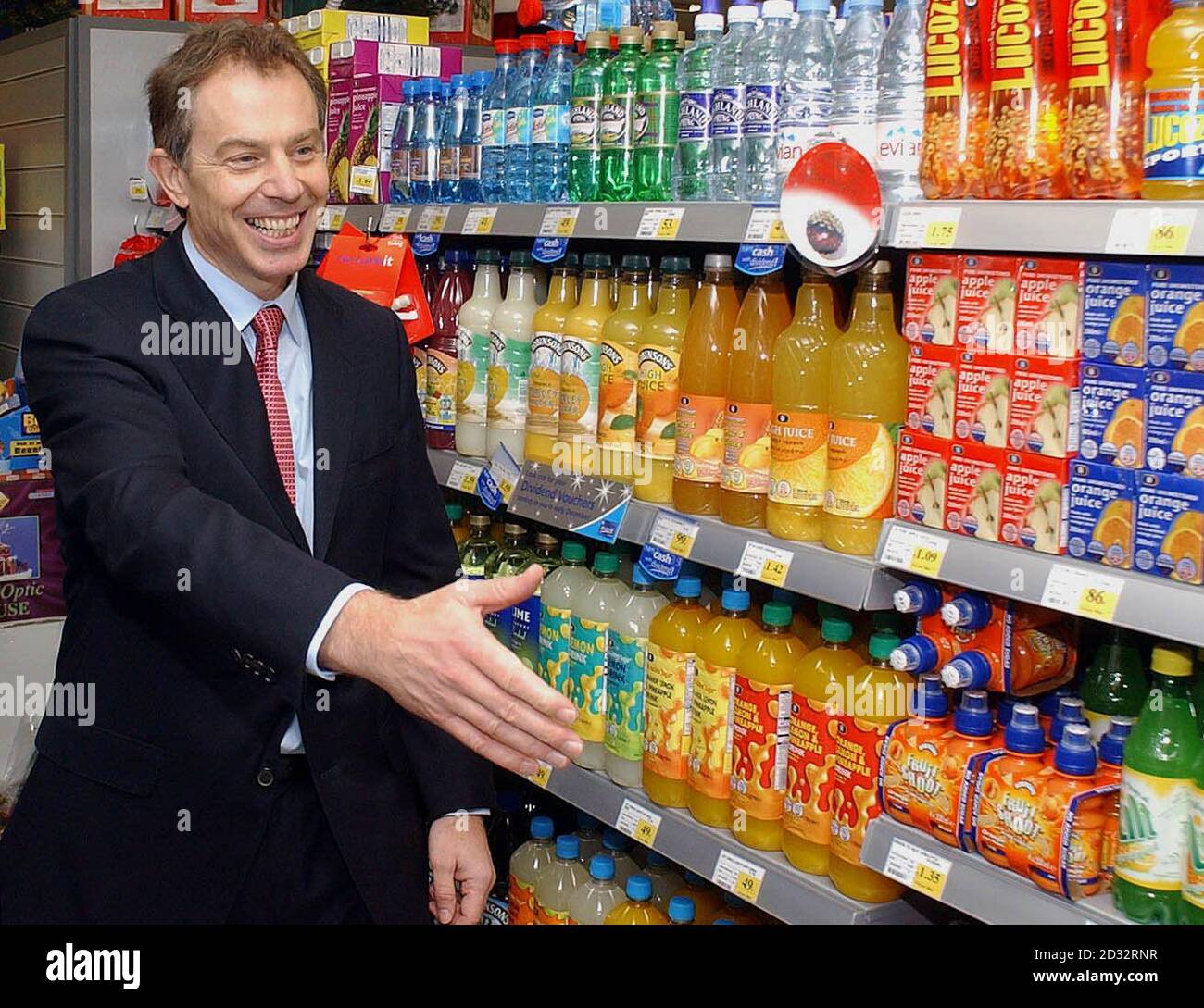 Premierminister Tony Blair reicht seine Hand, um die Mitarbeiter im Co-op-Laden in Middlesbrough zu begrüßen. Herr und Frau Blair haben in einem neu eröffneten Co-op-Laden einen halben Kilometer von ihrem Wahlkreis entfernt Weihnachtseinkäufe gemacht und einen Stapel Schokolade und eine Flasche Whisky gekauft. Stockfoto
