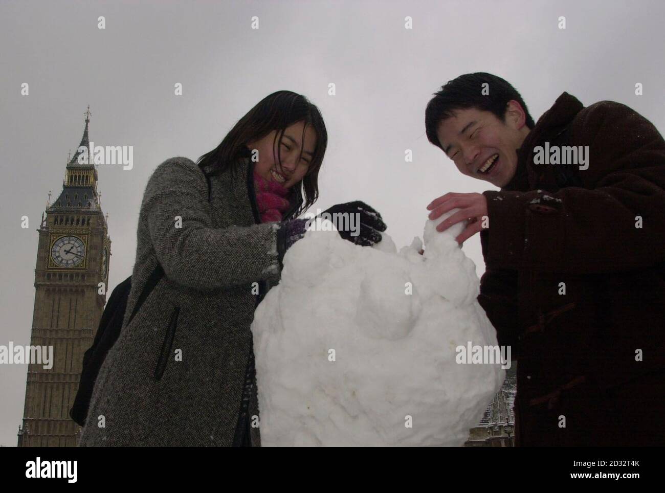 Shelley Ang (links), aus Penang in Malaysia und Shunsuke Niwa aus Osaka in Japan, beide englischsprachige Studenten, bauen einen Schneemann auf dem Parliament Square gegenüber dem Houses of Parliament, als ein Schneesturm London trifft. * in einer Nacht mit starkem Frost sanken die Temperaturen in Farnborough, Hampshire und Hawarden im Nordosten von Wales bis auf minus 8C und in der Highland-Stadt Aviemore bis auf minus 16C. PA Foto : Johnny Green. Stockfoto