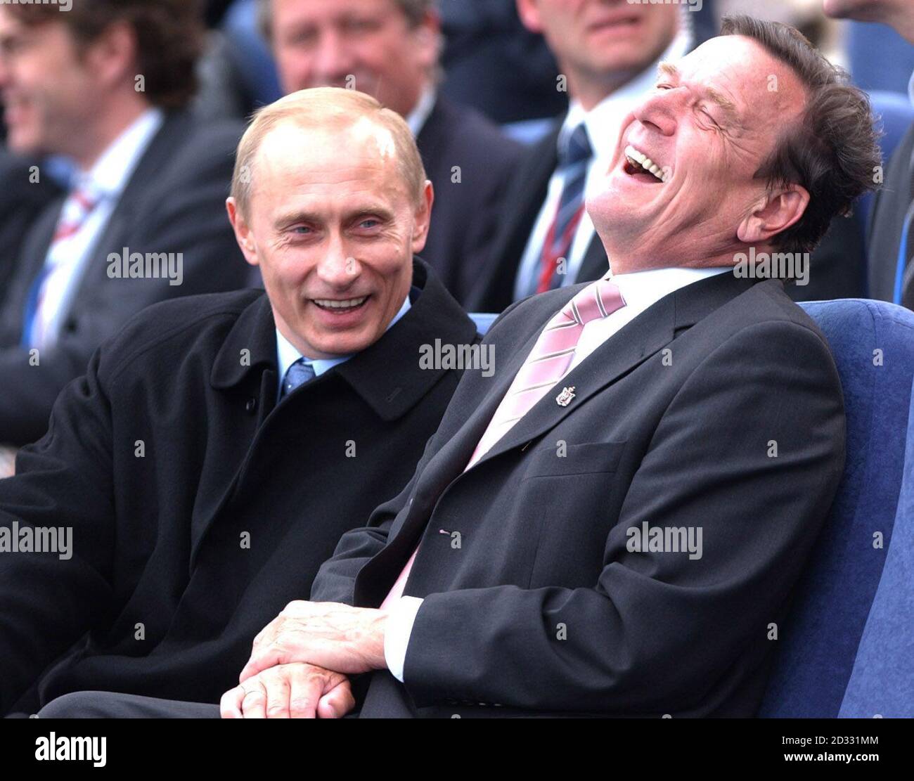 Der russische Staatschef Vladamir Putin (links) teilt einen Witz mit dem deutschen Bundeskanzler Gerhard Schröder, während sie ein Festival auf dem Fluss in St. Petersburg, Russland, ansahen, um das hundertjährige Jubiläum der Stadt zu feiern. Stockfoto