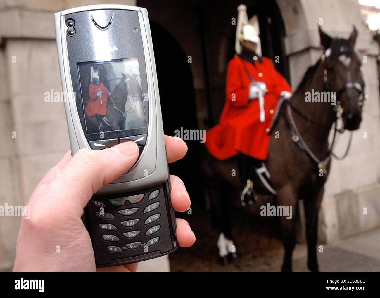 Ein mobiler Benutzer nimmt ein Foto von einem Mitglied der Household Cavalry in Londons Whitehall mit der eingebauten Kamera auf einem Nokia-Telefon auf. Branchenexperten hoffen, dass bis Ende dieses Jahres Mobilfunkabonnements mehr als 1.6 Milliarden betragen werden - 1 von vier der Weltbevölkerung - und dass Bilder, die von Mobiltelefonen gesendet werden, die traditionellen Weihnachtspostkarten einiger wichtiger Resorts in Europa überholen könnten. Stockfoto