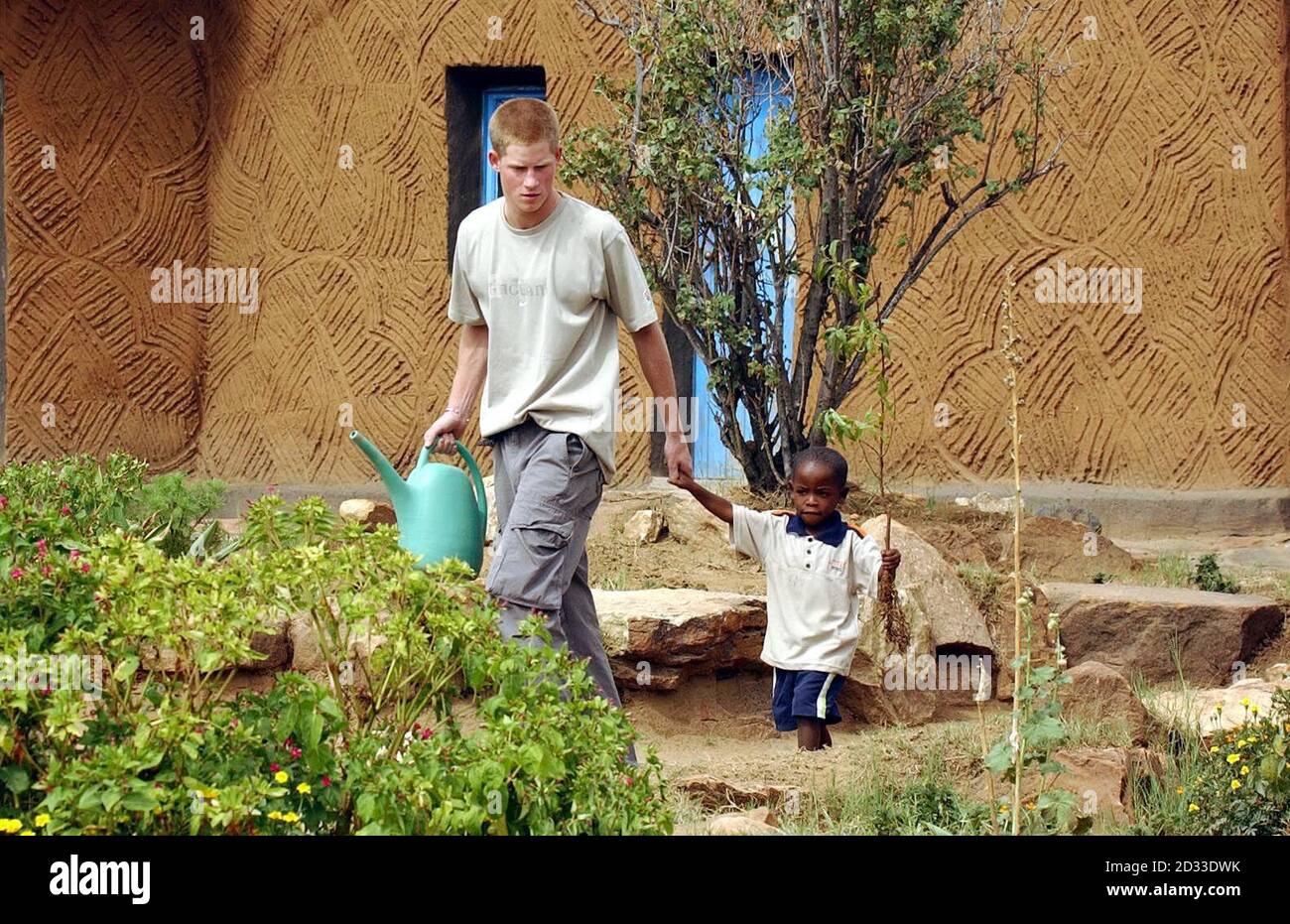 Prinz Harry, der jüngere Sohn des britischen Prinzen Charles, führt die junge Waise Mutsu Potsdamer, 4, an der Hand, um einen Pfirsichbaum zusammen im Mants'ase Kinderheim für Waisenkinder in der Nähe von Mohale's Hoek, etwa 60 Meilen südlich von Maseru in Lesotho, zu Pflanzen. Der 19-jährige Prinz ist im Rahmen seines GAP-Jahres seit drei Wochen im südafrikanischen Land und hat auch AIDS-Opfer und TB-Betroffene getroffen, bei anderen Gemeinschaftsprojekten mitgeholfen und einige Besichtigungen mitgemacht. Stockfoto