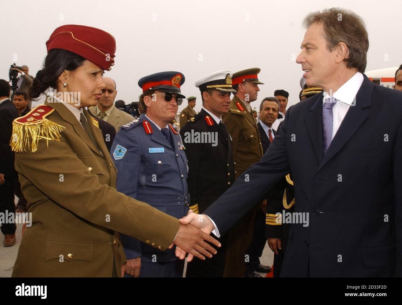 Premierminister Tony Blair (R) schüttelt die Hände mit Mitgliedern des libyschen Militärs, als er zu Gesprächen mit dem libyschen Führer Oberst Muammar Gaddafi vor ihren Gesprächen in Tripolis eintrifft. Stockfoto