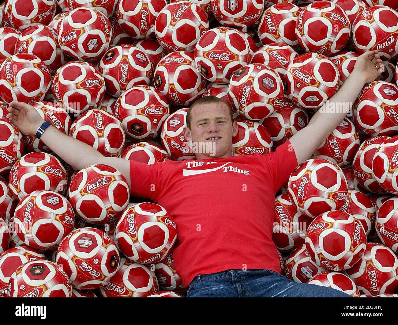Everton-Star Wayne Rooney mit Tausenden von Coca-Cola-Fußbällen, die auf den Straßen von Liverpool veröffentlicht wurden. Die Softdrinks-Firma bringt die Nation in diesem Sommer in den Treten, indem sie eine Million Fußbälle auf speziellen Dosen, Flaschen und Multipacks von "Coca-Cola" verschenkt und eine "Get Kicking"-Tour startet, um alle im ganzen Land zu ermutigen, Spaß beim Kicking zu haben. Stockfoto
