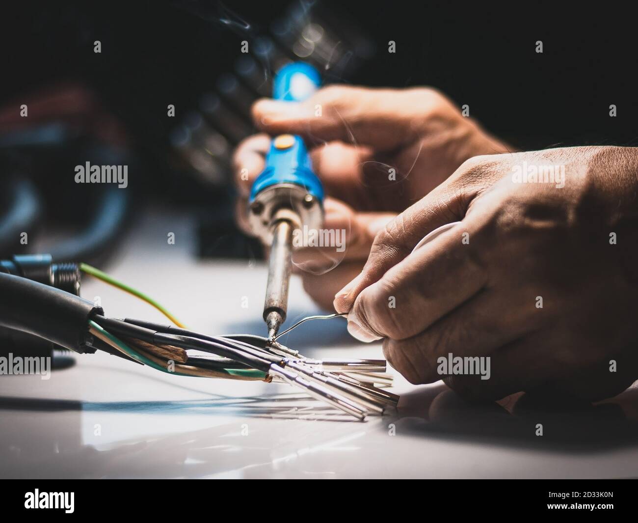 Elektriker verwenden einen Lötkolben, um die Drähte mit dem Metallstift mit  Lötkabel zu verbinden Stockfotografie - Alamy