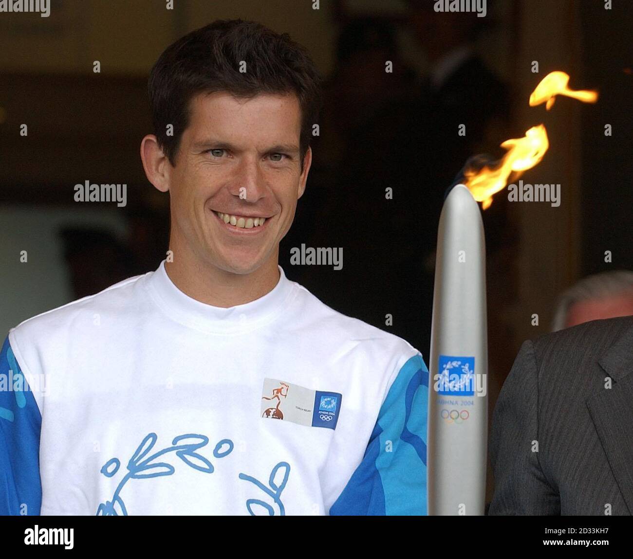 Tim Henman hält die olympische Fackel, nachdem er sie von Sir Roger Bannister vor dem Center Court bei den Lawn Tennis Championships in Wimbledon erhalten hat. Henman übergab die Flamme später an die ehemalige Meisterin Virginia Wade für die Reise nach Zentral-London. Stockfoto