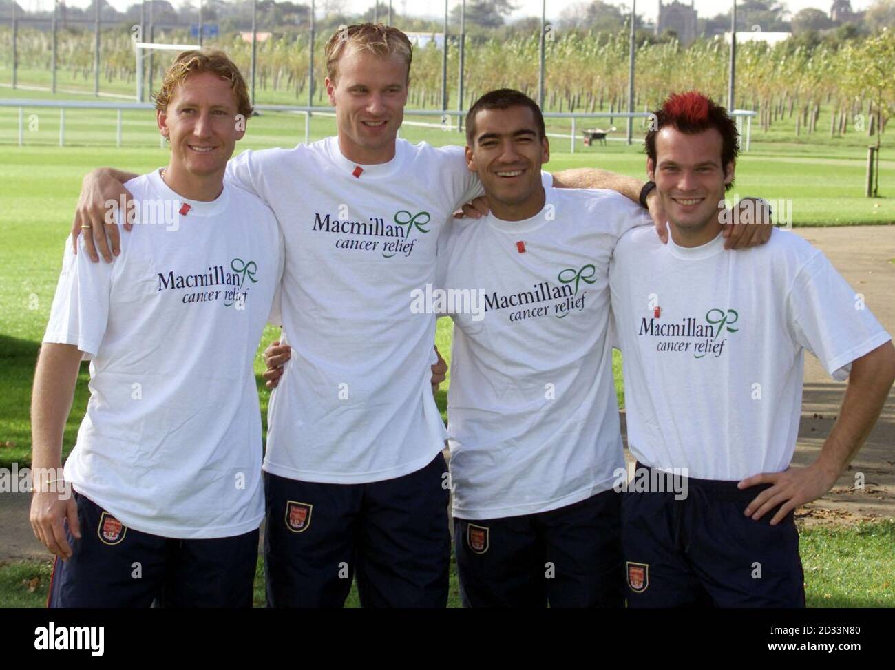 Die Arsenal-Spieler Dennis Bergkamp (2. V.l.), Giovani van Bronckhorst (3. V.l.), Freddie Ljungberg (ganz rechts) und Ray Palour (links) hefteten neue Farben an ihre Brust, um das vierte Jahr der Unterstützung ihres Clubs für Macmillan Cancer Relief anzustoßen. Die Arsenal Pin Abzeichen sind für eine vorgeschlagene Spende von je 1 im Club und in JJB Sports Outlets erhältlich, und alles Geld, das gesammelt wird, wird für die Finanzierung von Macmillans Spezialdiensten verwendet, die dazu beitragen, das Leben von Krebspatienten und ihren Familien zu erleichtern und unnötige Ängste zu reduzieren. Stockfoto