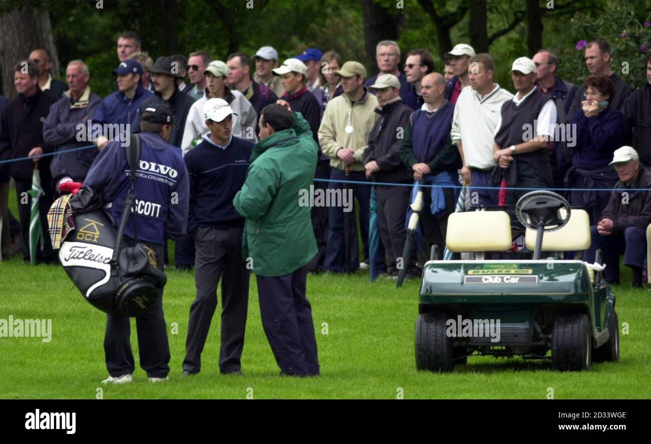 Der australische Adam Scott wird von einem Reglement Official angesprochen, der ihn darüber informiert, dass er während der 2. Runde der Volvo PGA Championship im Wentworth Club, Virginia Water, eine 2-Takt-Strafe für eine Regelverletzung am 5. Loch erhalten hat. Stockfoto