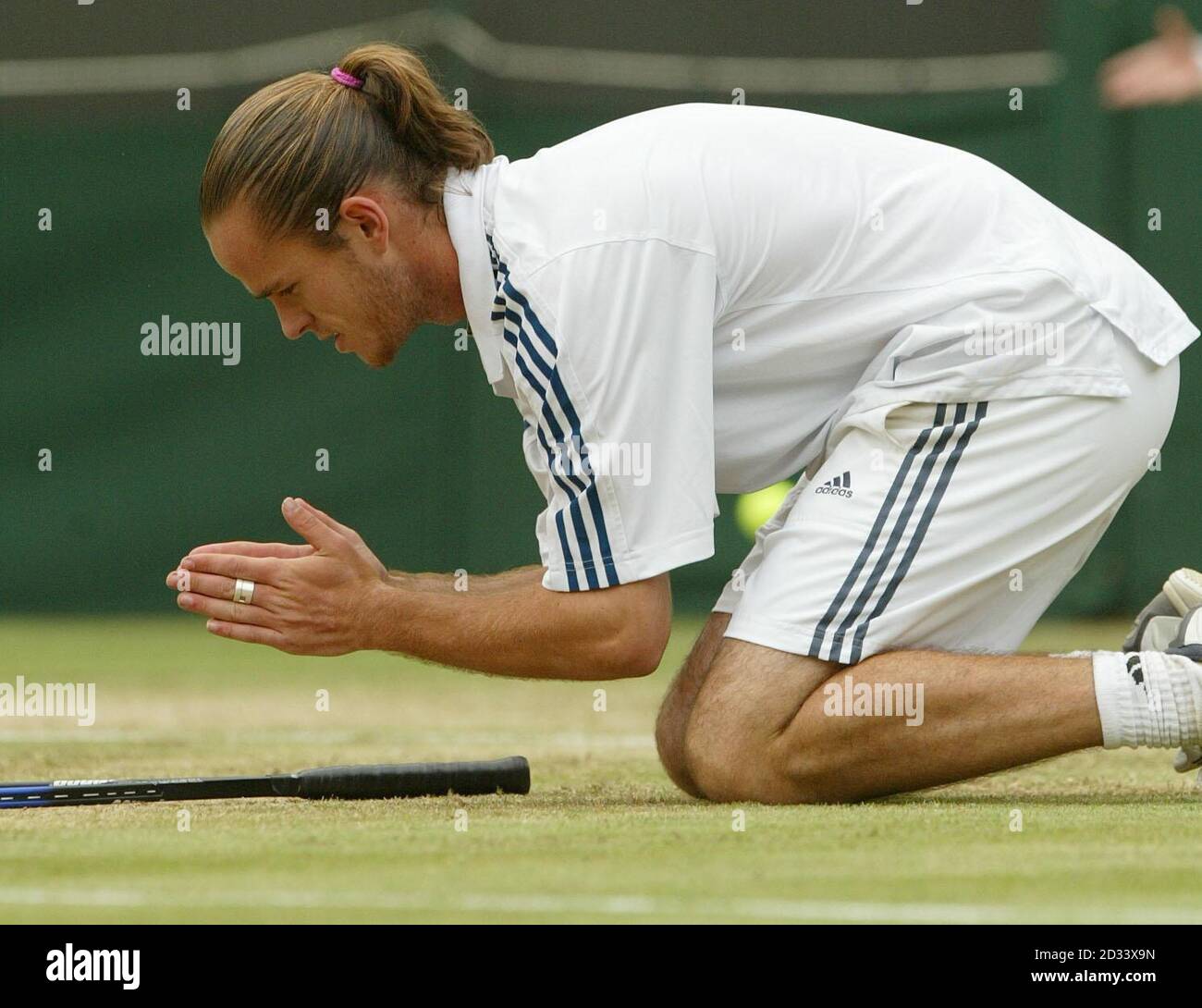NUR FÜR REDAKTIONELLE ZWECKE: KEINE KOMMERZIELLE NUTZUNG. Xavier Malisse aus Belgien fällt auf die Knie, nachdem er den Holländer Richard Krajicek im Viertelfinalspiel der Herren am ersten Platz in Wimbledon besiegt hat. Malisse kämpfte gegen Krajicek durch fünf Sätze und gewann schließlich 6:1/4:6/6:2/3:6/9:7. Stockfoto NUR FÜR REDAKTIONELLE ZWECKE: KEINE KOMMERZIELLE NUTZUNG. Xavier Malisse aus Belgien fällt auf die Knie, nachdem er den Holländer Richard Krajicek im Viertelfinalspiel der Herren am ersten Platz in Wimbledon besiegt hat. Malisse kämpfte gegen Krajicek durch fünf Sätze und gewann schließlich 6:1/4:6/6:2/3:6/9:7. Stockfoto