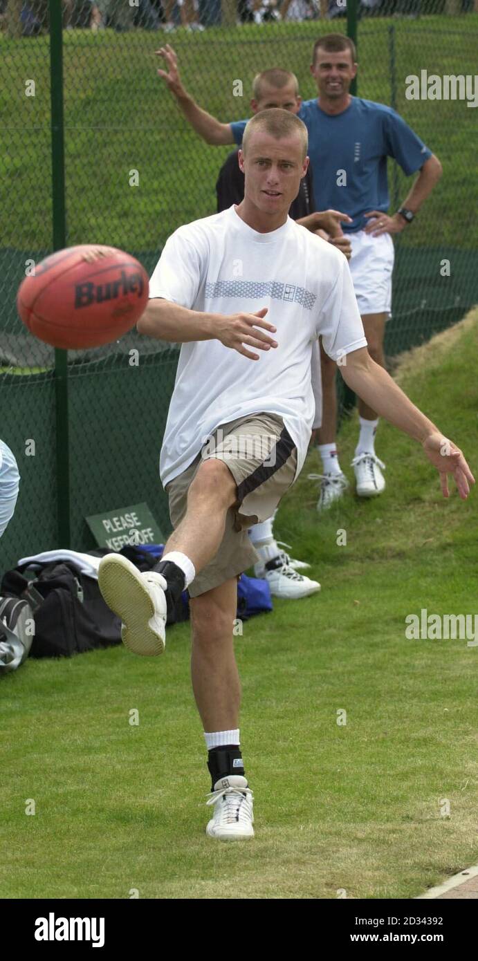 NUR ZUR REDAKTIONELLEN VERWENDUNG, KEINE HANDYNUTZUNG Lleyton Hewitt legt auf den Übungsplätzen des All England Club in South London einen Aussie Rules Football ab, da die letzten Vorbereitungen vor dem Start der Wimbledon Tennis Championships 2003 getroffen werden. Stockfoto