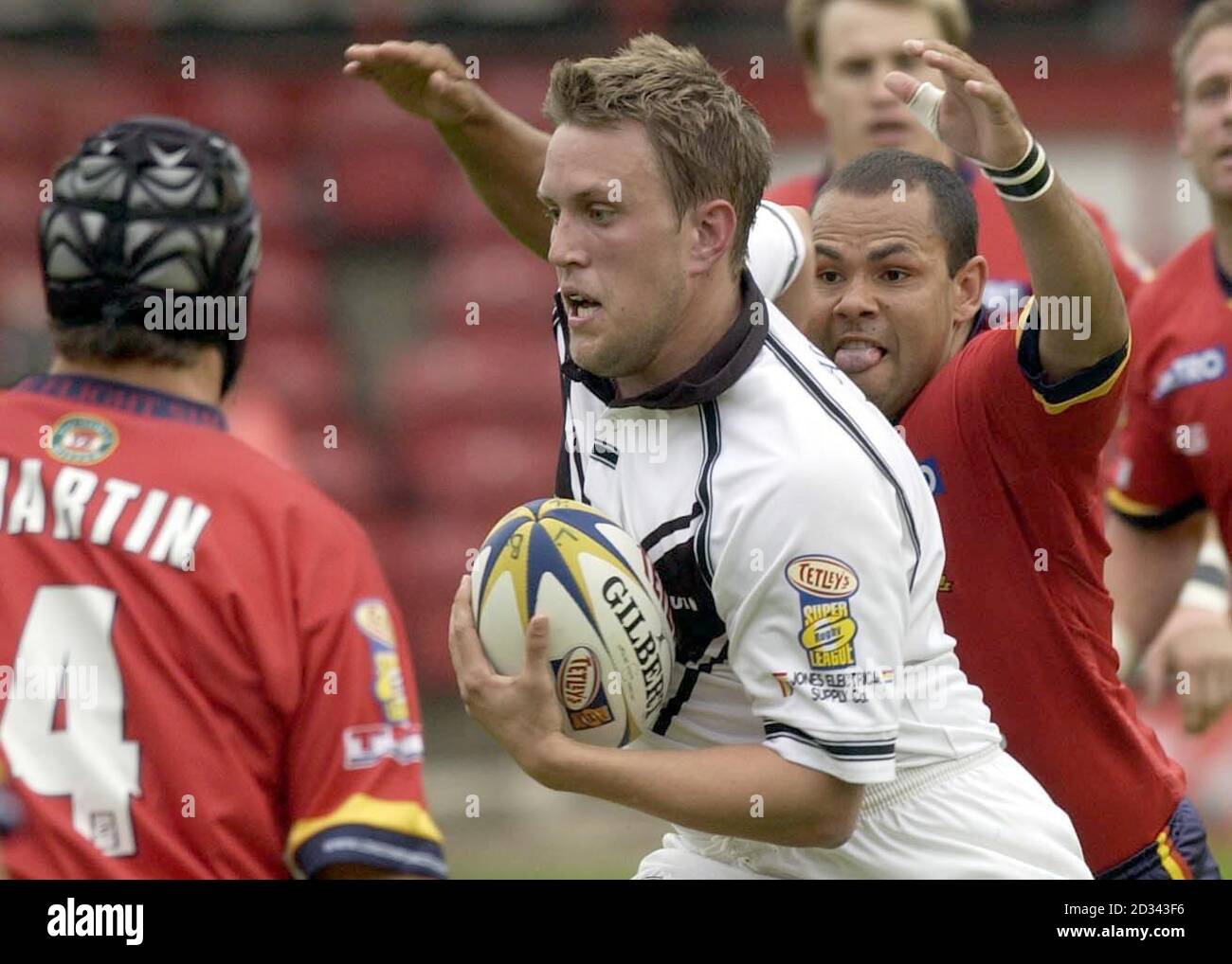 Hulls lockerer Stürmer Peter Lupton bricht, bevor er von Dennis Moran aus London Bronco während des Tetley's Super League-Spiels zwischen London Broncos und Hull im Griffin Park, London, gestoppt wird. Stockfoto