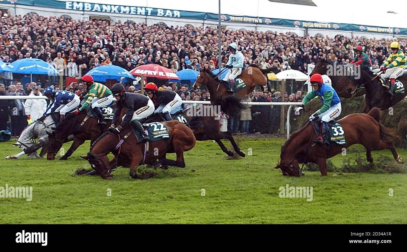 Eine Vielzahl von Fallern am ersten Zaun während der John Smith's Grand National mit Lord Atterbury (33) und Franzosen Creek (22) im Vordergrund Stockfoto