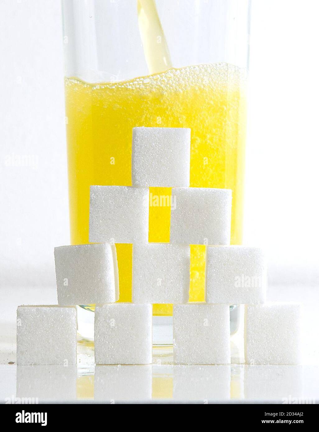 Ein orangefarbenes kohlensäurehaltiges Getränk mit Zuckerwürfeln als Getränk mit zuckerhaltigen Getränken könnte laut Forschung fast 8,000 Fälle von Typ-2-Diabetes pro Jahr verursachen. Stockfoto