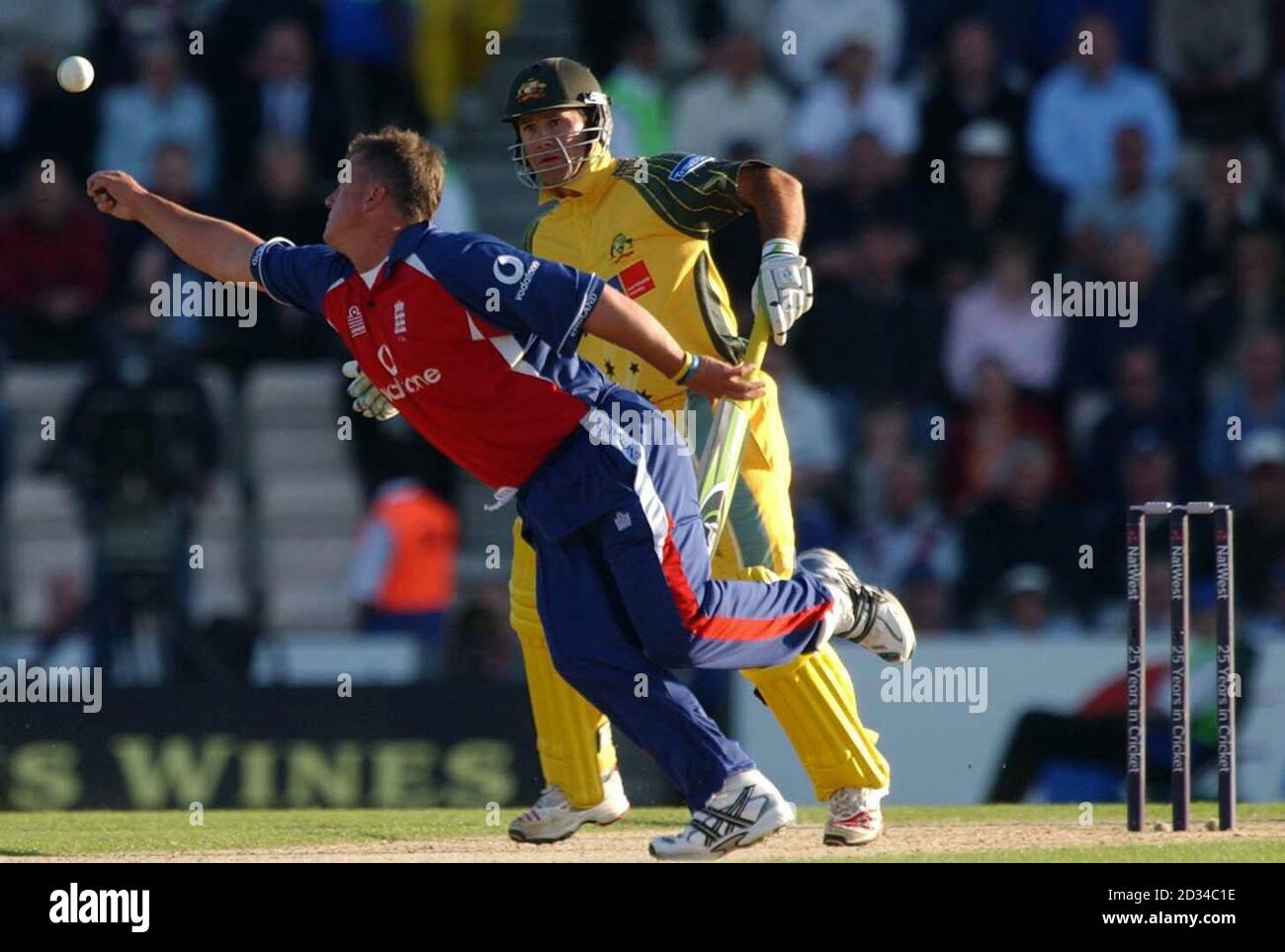 Der australische Kapitän Ricky Ponting (R) sieht zu, wie Englands Darren Gough sich nach einem Fang von seiner eigenen Lieferung streckt. Stockfoto