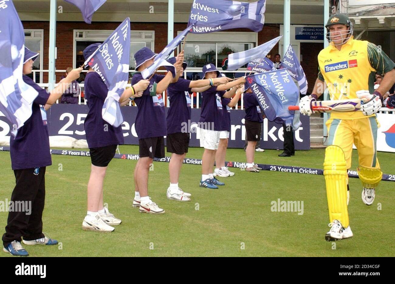 Der Australier Matthew Hayden läuft an Schulkindern vorbei, die Flaggen tragen, während er sich auf ihre Innings vorbereitet. Stockfoto