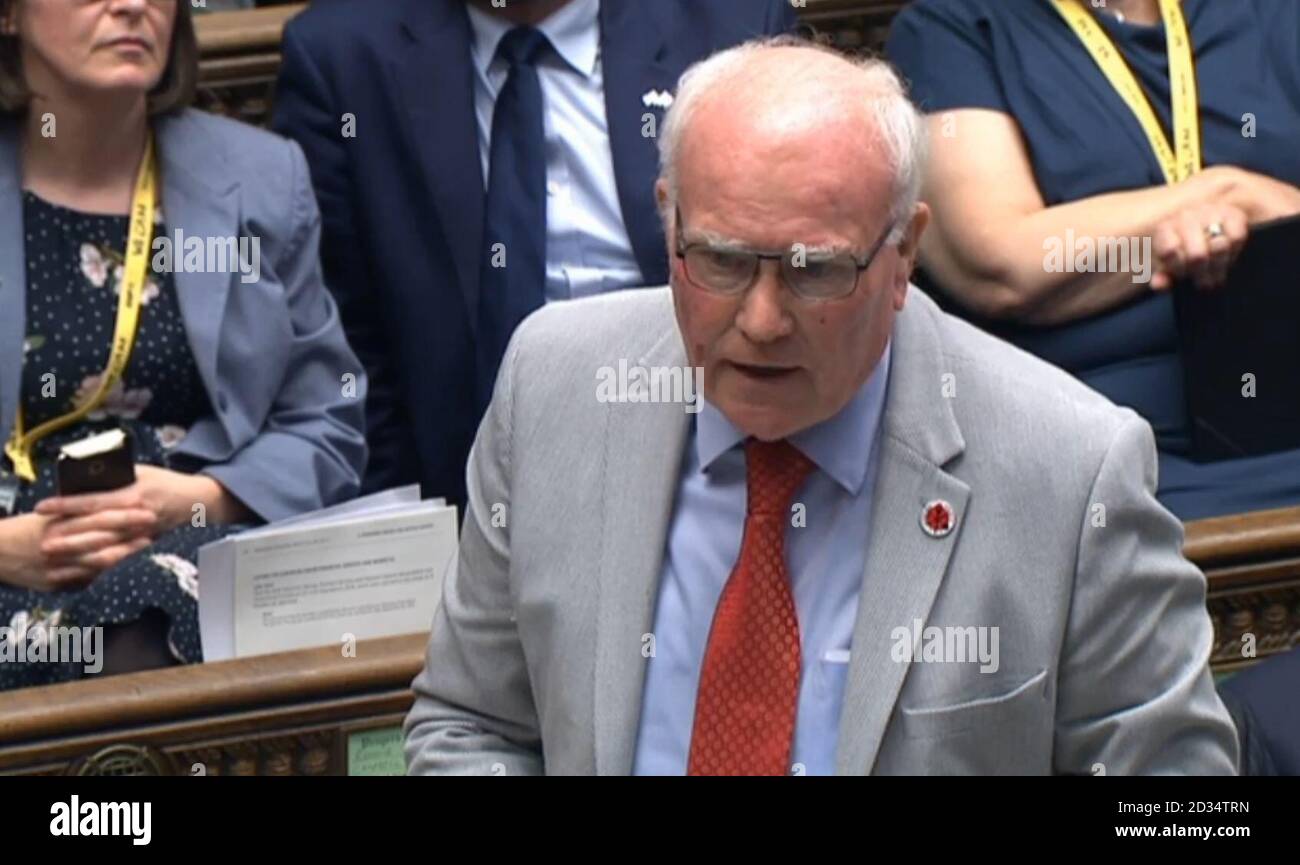 Die Labour-Abgeordnete Ronnie Campbell, die Premierminister Theresa May ein Schild mit der aktuellen Staatsverschuldung des Vereinigten Königreichs übergab, nachdem sie auf der Fragestunde des Premierministers über die Finanzen des Landes befragt wurde. Stockfoto