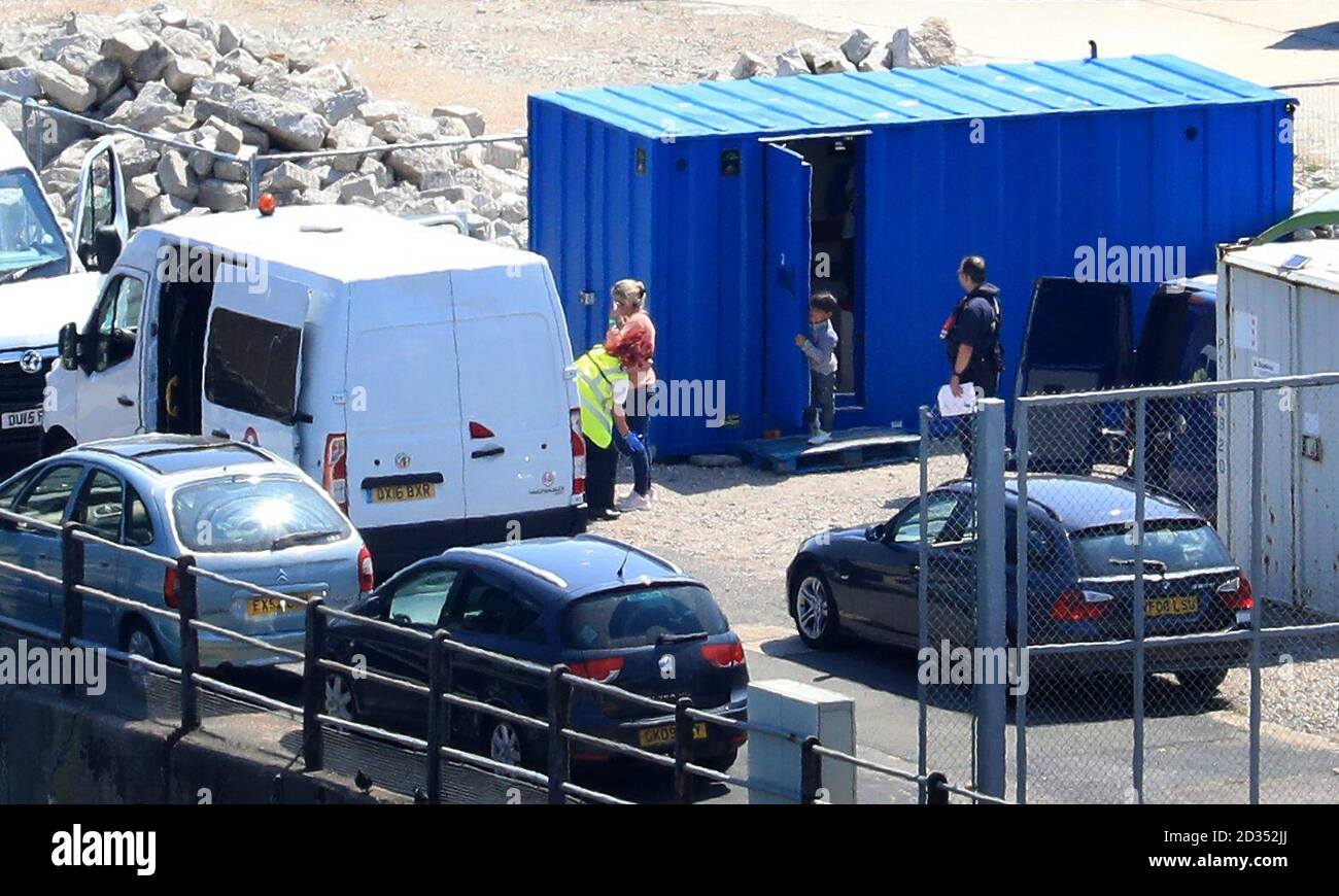 Ein kleiner Junge beobachtet, wie seine Mutter von Grenzschutzbeamten in Dover, Kent, verarbeitet wird, nachdem sie am frühen Dienstagmorgen von kleinen Booten im Kanal abgeholt wurden. Stockfoto