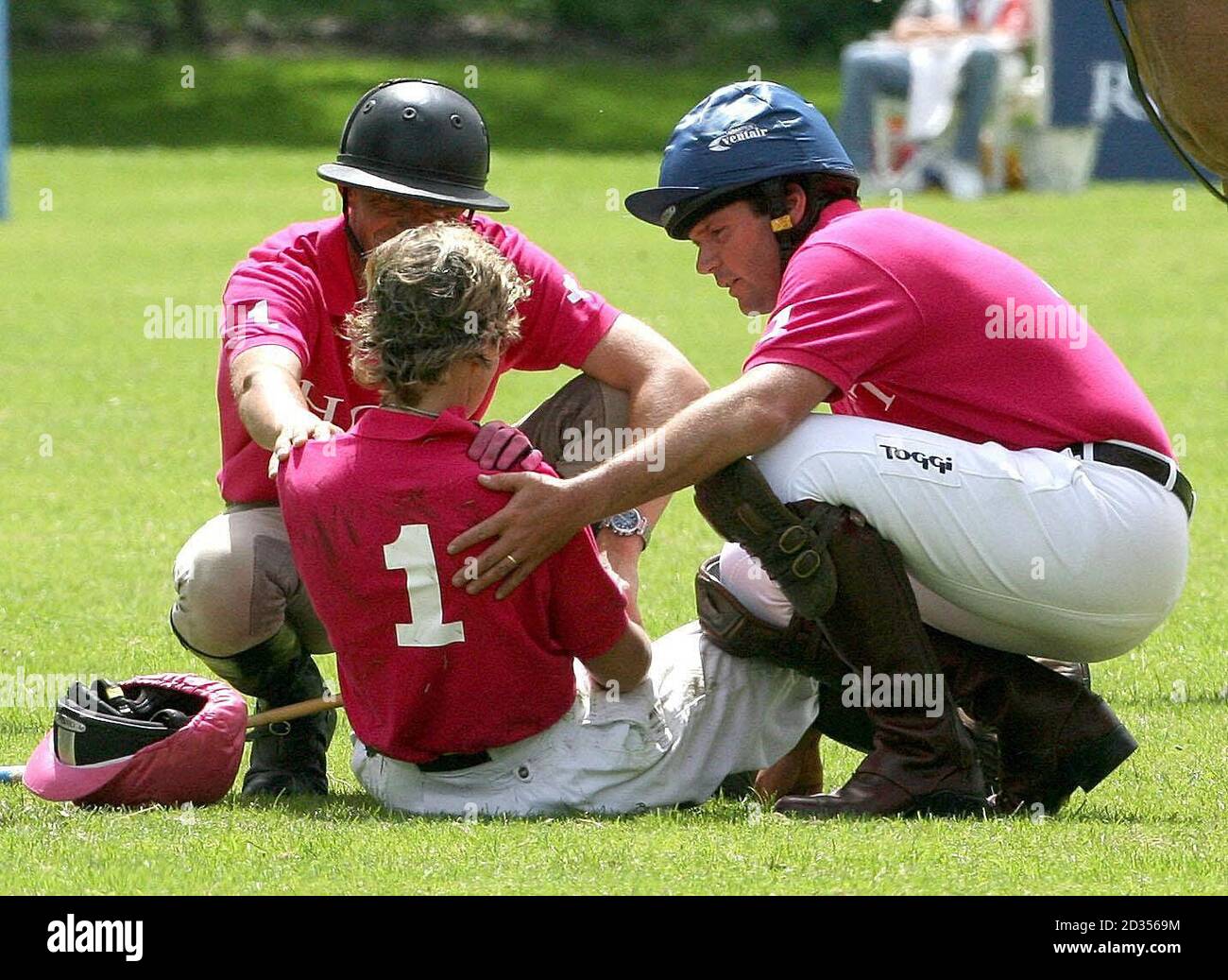 Lucinda Fredericks wird von Ehemann Clayton Fredericks (rechts) begleitet, nachdem er beim Spiel Jockeys gegen Eventers Charity im Tidworth Polo Club in Wiltshire von ihrem Pferd geworfen wurde. Stockfoto