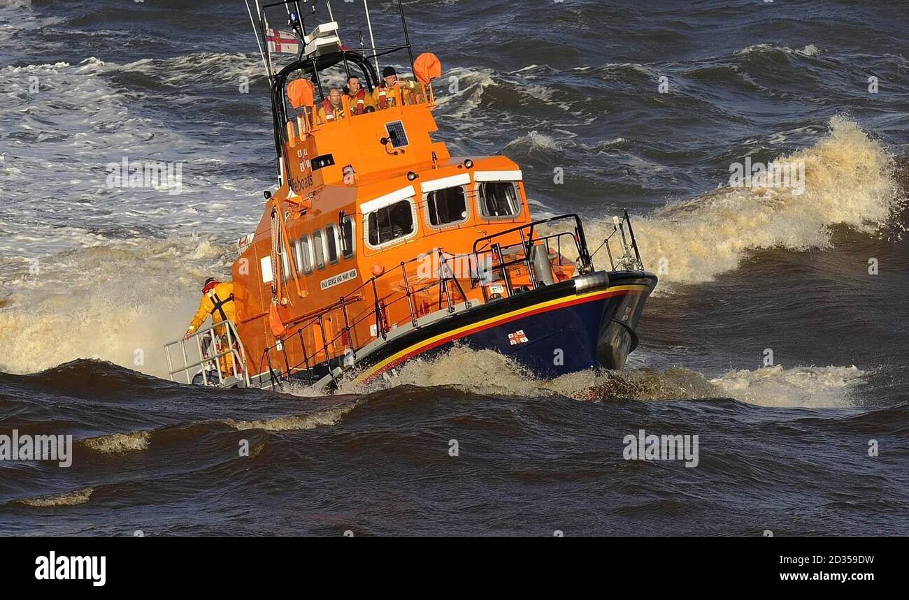 Whitby Life Boat Crew kehrt zurück, nachdem ein kleines Boot gesunken ist In rauer See außerhalb von Whitby Harbour Stockfoto