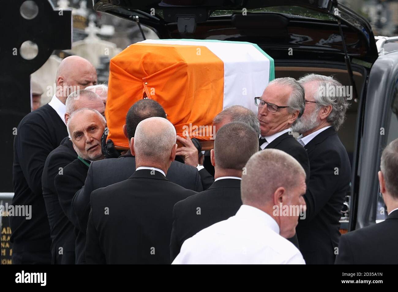 Sean Murray (vorne links), Gerry Kelly (rechts) und Gerry Adams (hinten rechts) tragen den Sarg der ehemaligen IRA-Hauptfigur Bobby Story, nachdem sie am Milltown Cemetery in West Belfast angekommen ist. Stockfoto