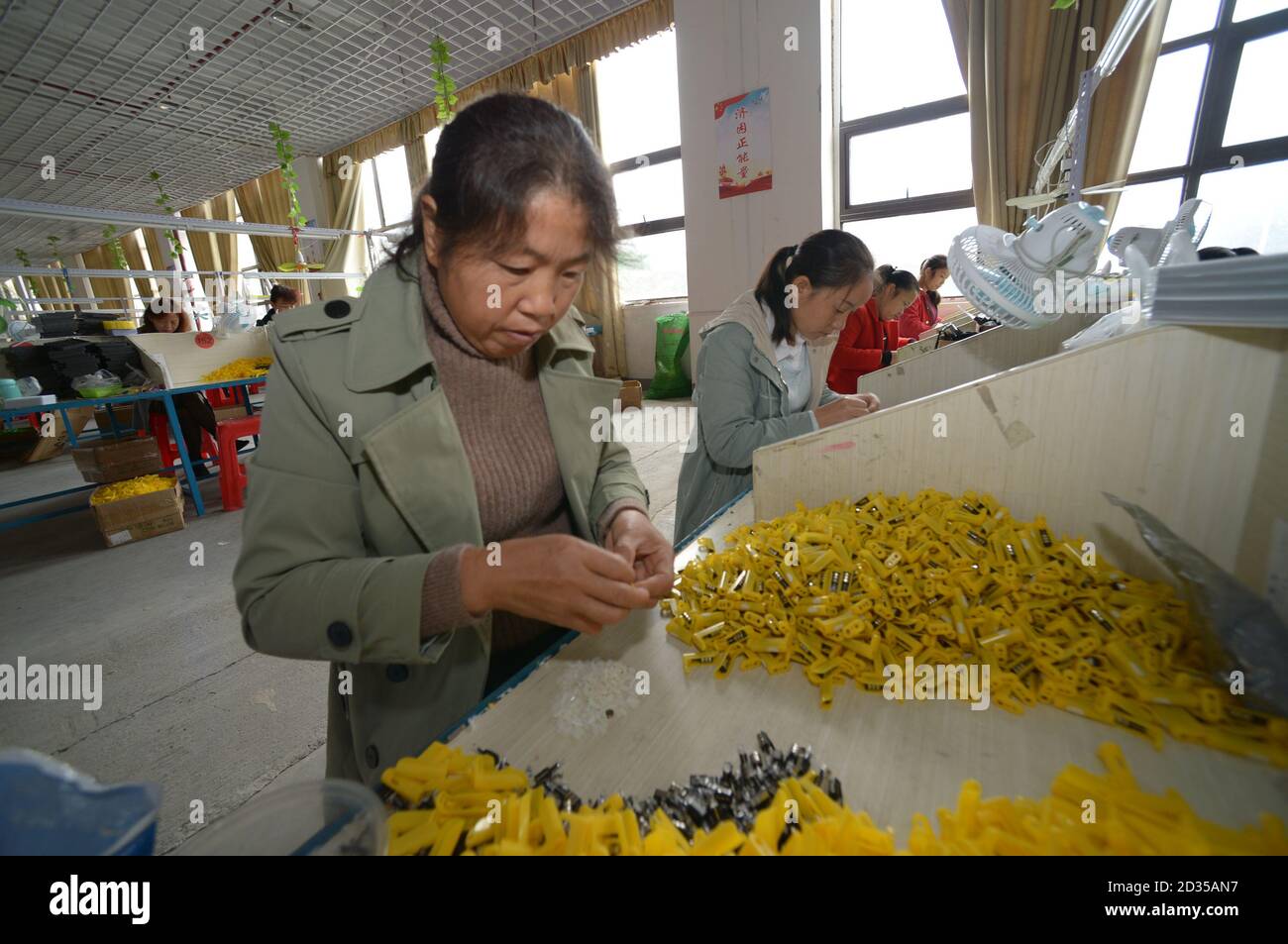 Yuping, Chinas Provinz Guizhou. Oktober 2020. Arbeiter stellen Feuerzeuge in einer Werkstatt eines Umsiedlungsstandortes im Autonomen Bezirk Yuping Dong, südwestlich der Provinz Guizhou in China, am 7. Oktober 2020. Workshops wurden eingerichtet, um umgesiedelten Dorfbewohnern während der Armutsbekämpfung des Bezirks zu helfen, und ein konstiertes Einkommen für insgesamt 2,639 Menschen aus neun Umsiedlungsgebieten zu erzielen. Quelle: Yang Ying/Xinhua/Alamy Live News Stockfoto