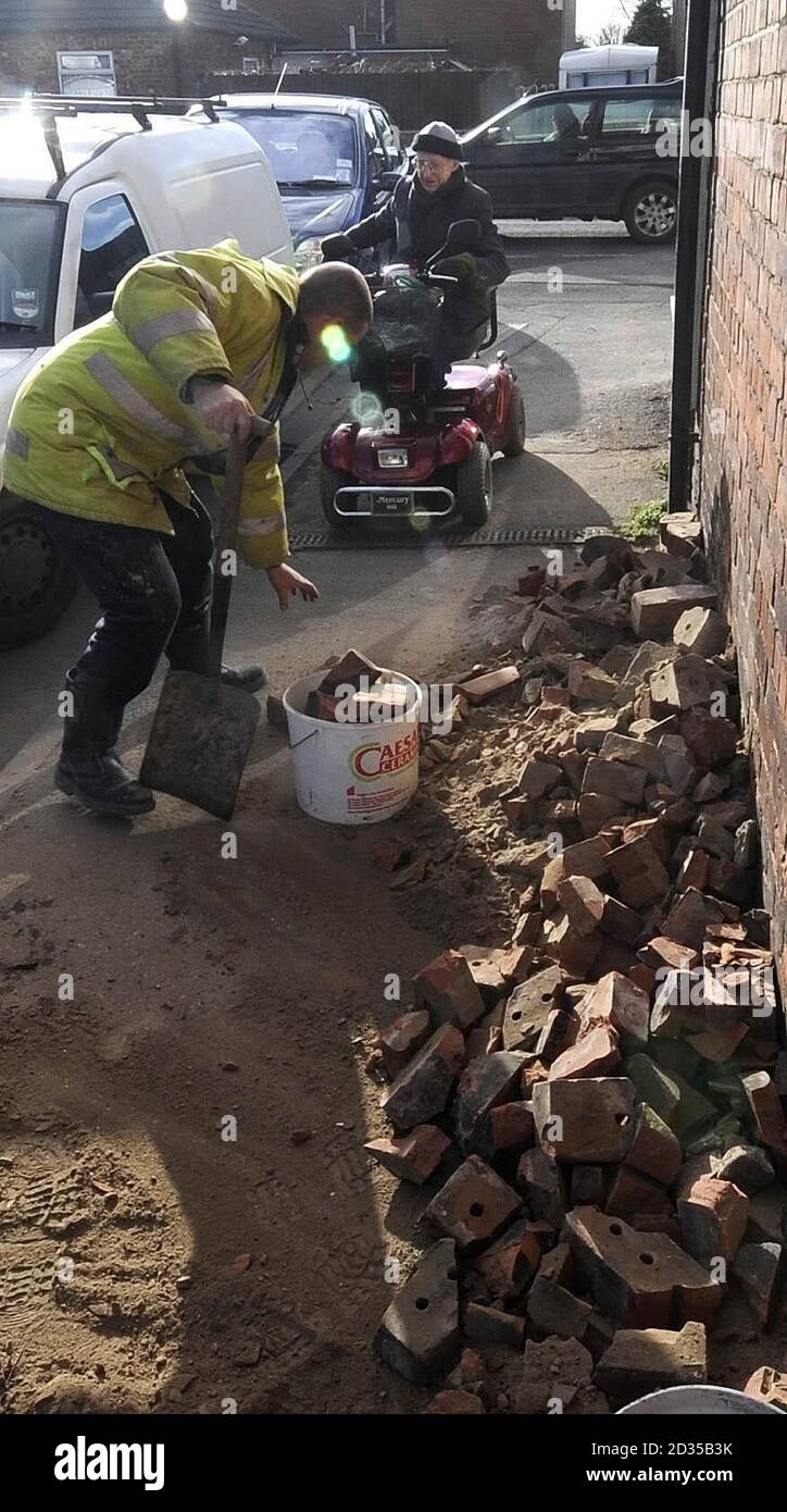 Schutt von einem eingestürzten Schornsteinstapel wird heute von Dean Perry (rechts) nach dem Erdbeben von Gehwegen vor einem Klempner und Bauherren Händler in Selby geräumt. Stockfoto