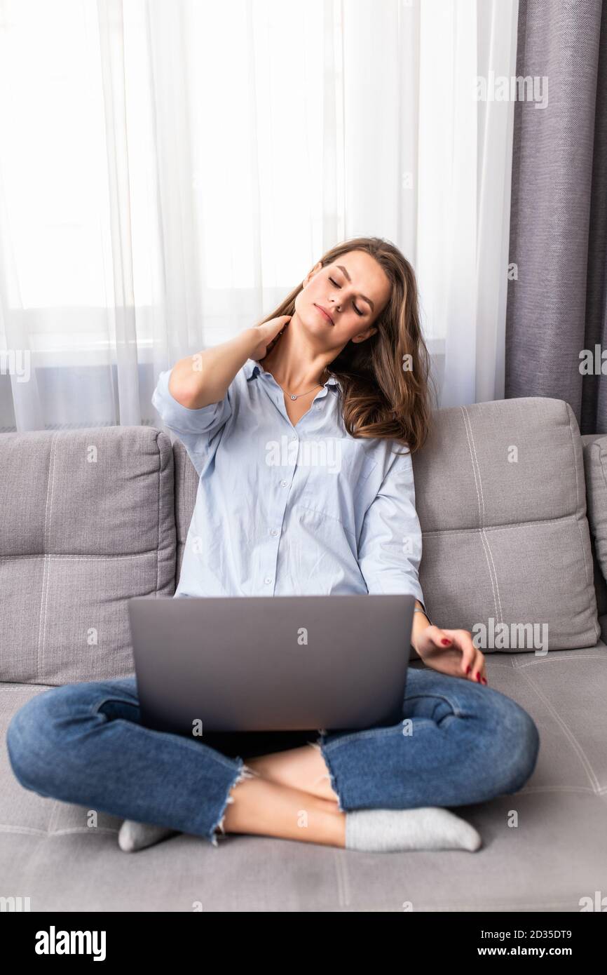 Frustriert traurig Frau müde Gefühl besorgt über Problem sitzen auf dem Sofa mit Laptop. Gestresste depressive Frau beunruhigt mit schlechten Nachrichten online lesen, Stockfoto