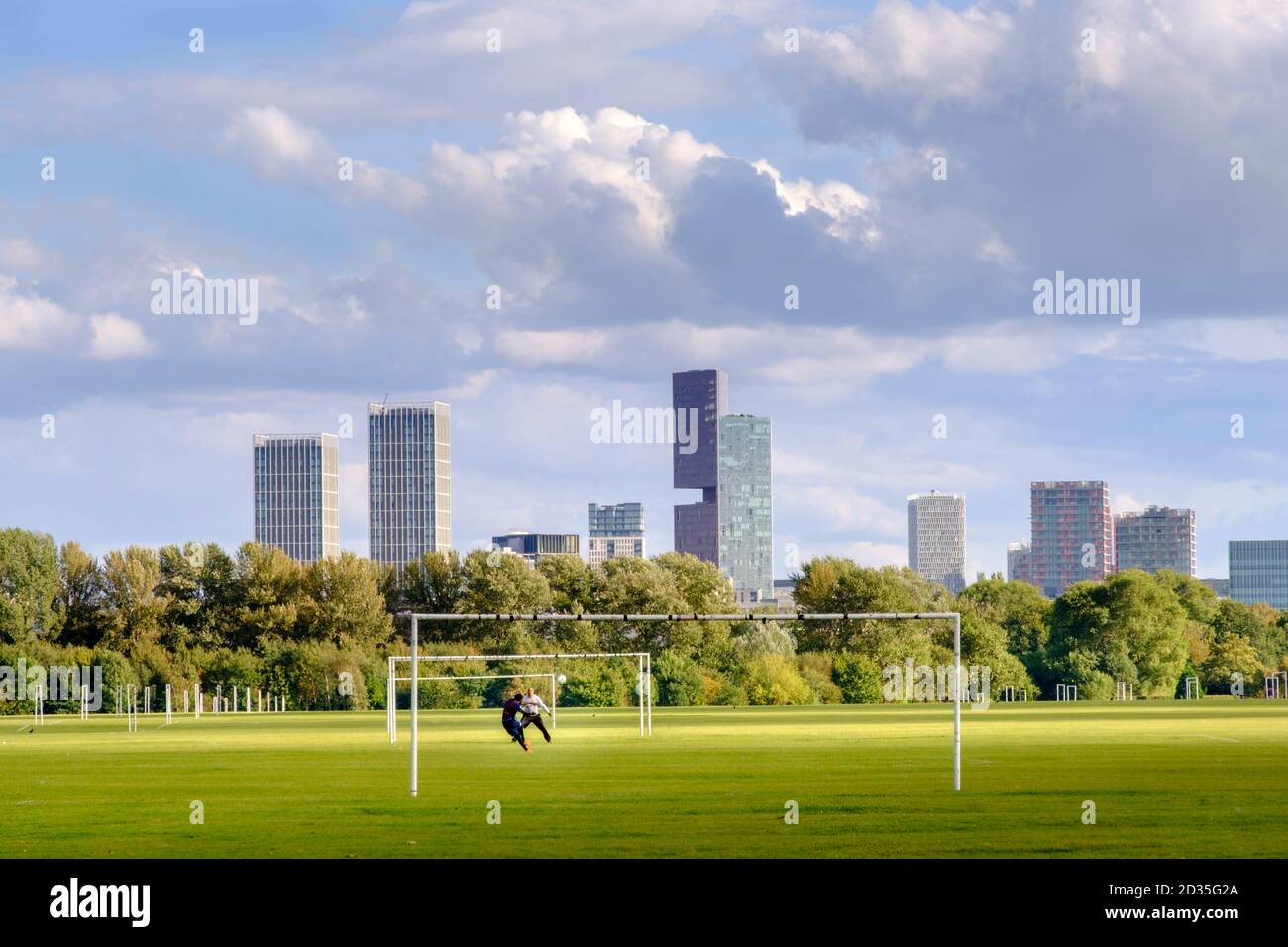 Großbritannien, London, Hackney. Fußballspieler trainieren auf den Spielfeldern der Hackney Marshes, hinter denen die Wolkenkratzer von Stratford stehen Stockfoto