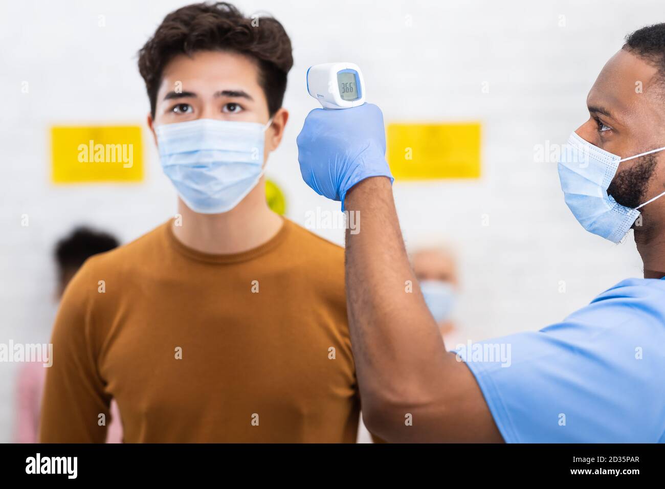 Krankenschwester Tun Temperatur Screening Für Asiatische Mann Patient Im Krankenhaus Stockfoto