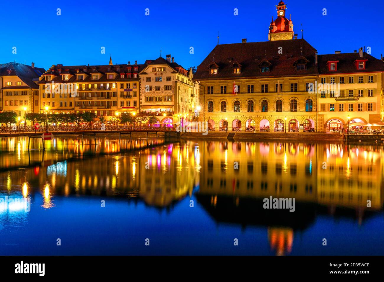 Mittelalterliche Stadt Luzern am Ufer des Vierwaldstatersees, beleuchtet bei Nacht. Kornschutte oder Rathaus und Gebäude spiegeln sich in Ruhe Stockfoto