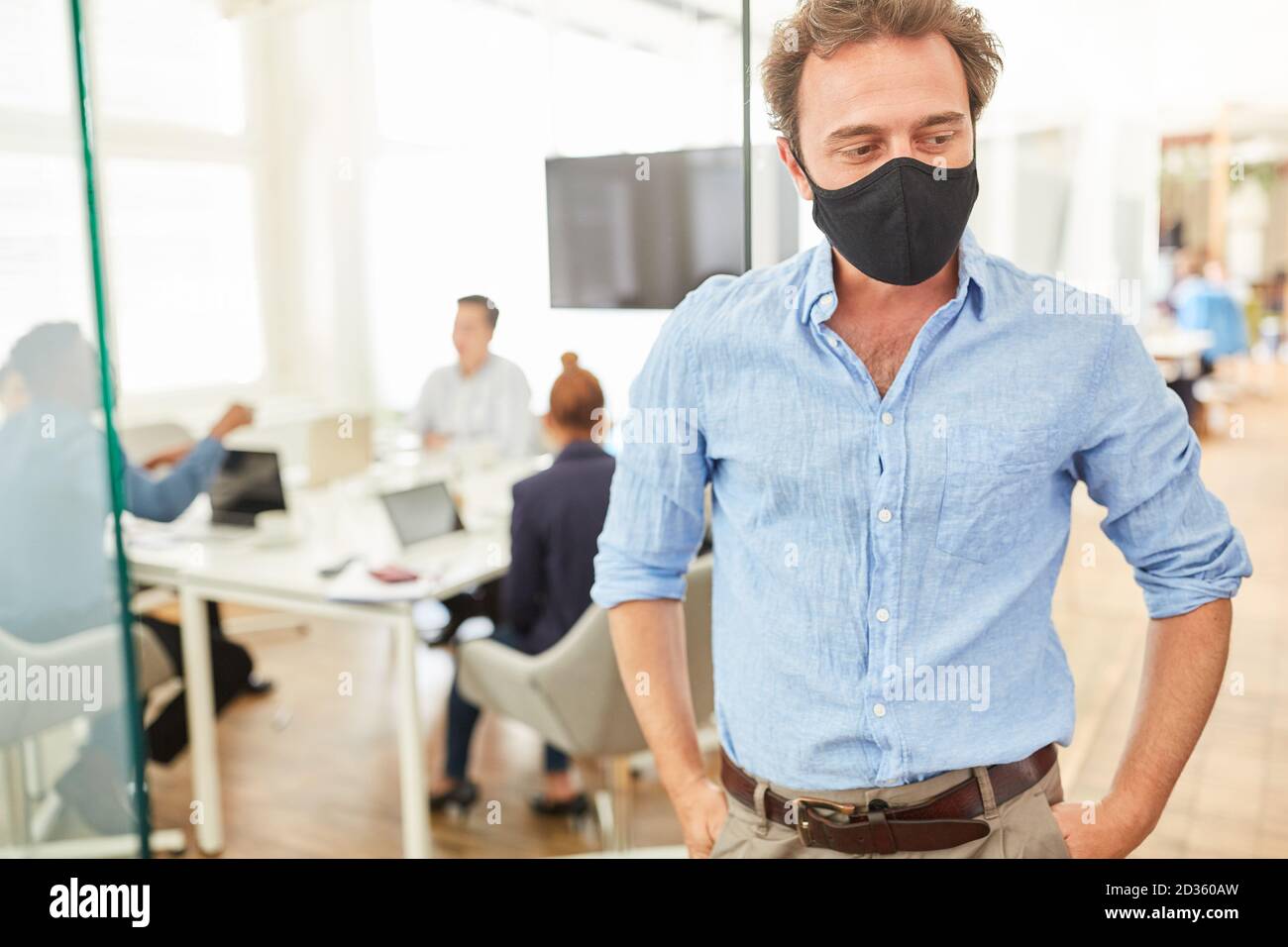 Geschäftsmann im Büro mit Mund- und Nasenschutz Als Prävention gegen Covid-19 Stockfoto