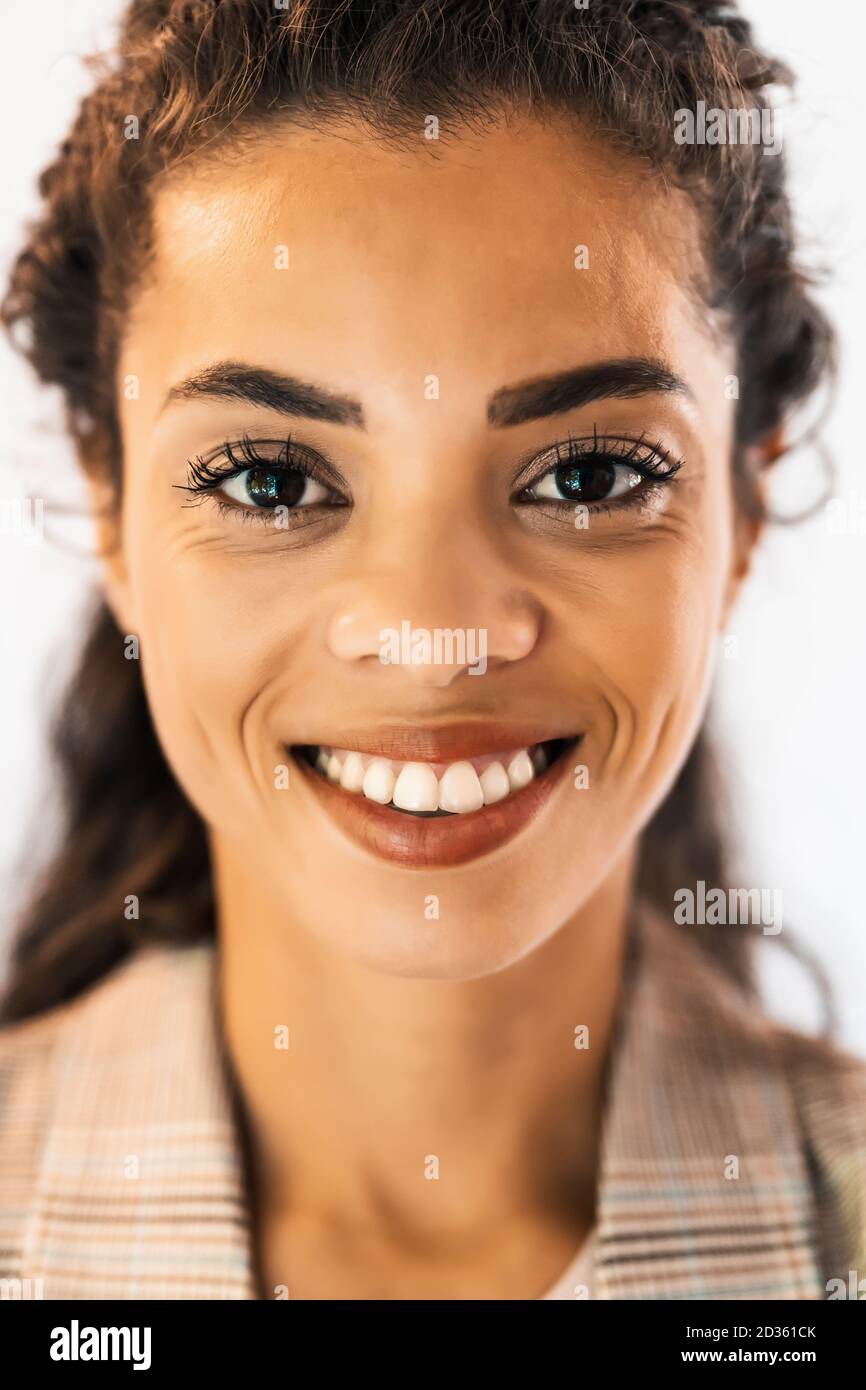 Porträt der schönen afroamerikanischen Frau, die Kamera anschaut und lächelt. Stockfoto