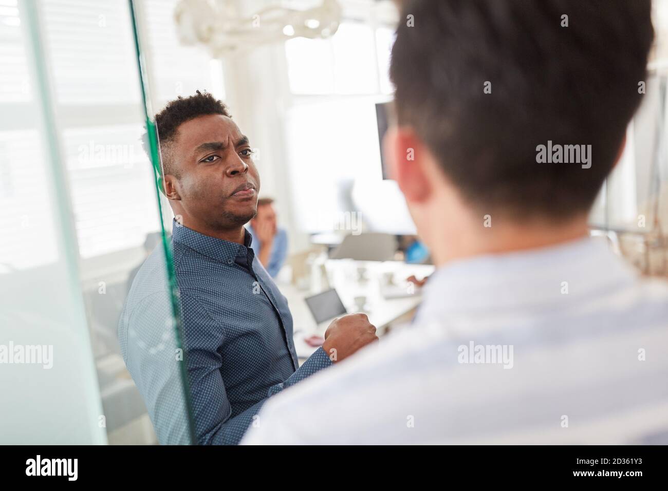 Afrikanischer Geschäftsmann streitet mit einem Kollegen im Büro Stockfoto
