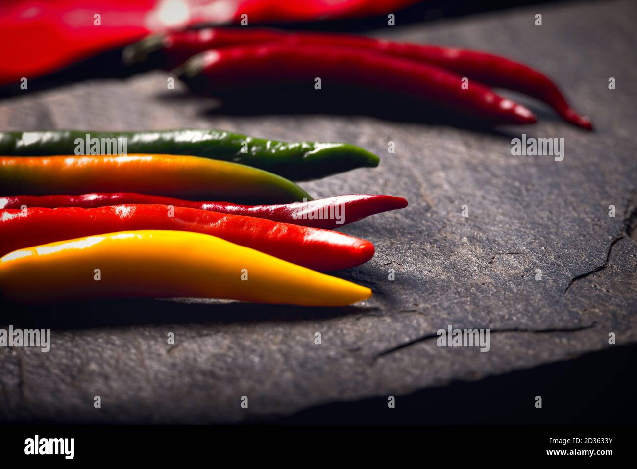 Verschiedene Chili auf einem Steinteller Stockfoto