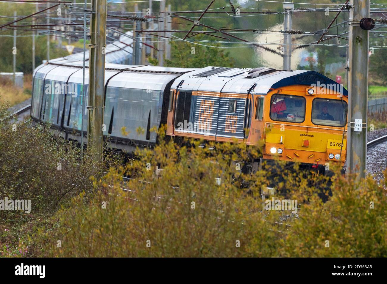 Diesel-Elektrolokomotive der Baureihe 66, die einen Drax-Biomassezug an der Kreuzung Winwick auf der West Coast Main Line schleppt. Stockfoto