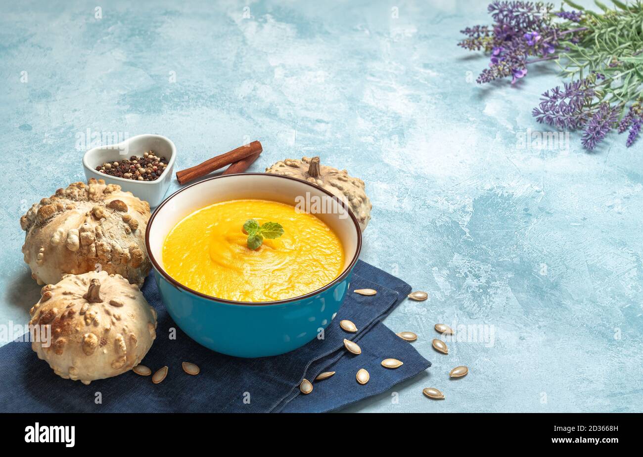 Nahaufnahme einer Kürbiscremesuppe, umgeben von Kürbissen Stockfoto