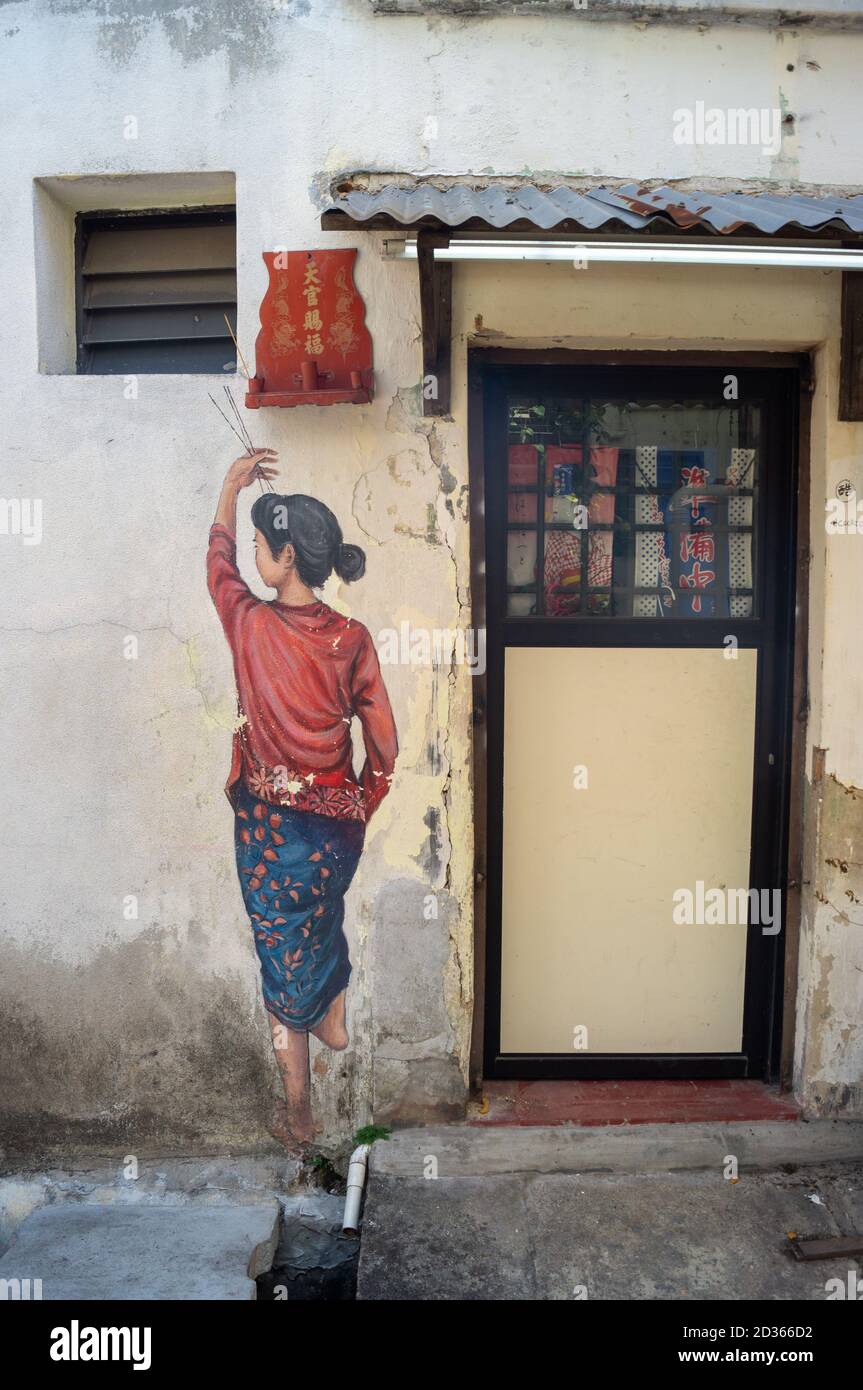 Georgetown, Penang/Malaysia - 29 2020. Feb: Wandbild eine chinesische Dame verbrennt an der Gasse einen Joss-Stick. Stockfoto