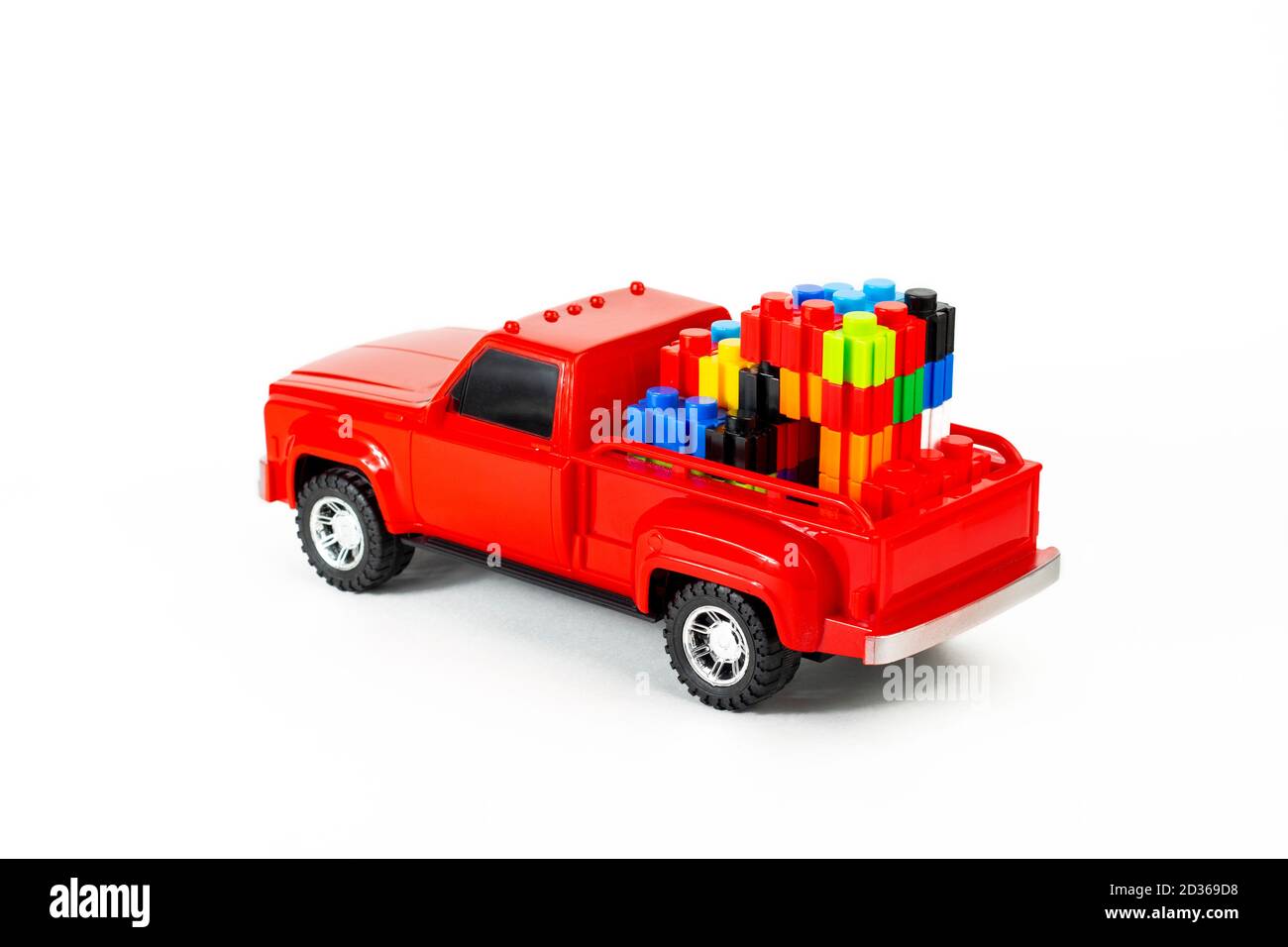 Bunte Würfel im roten trendigen Pickup-Kofferraum. Spielzeug LKW und Puzzles. Modernes Bau- und Entwicklungskonzept. Teil des Sets. Stockfoto