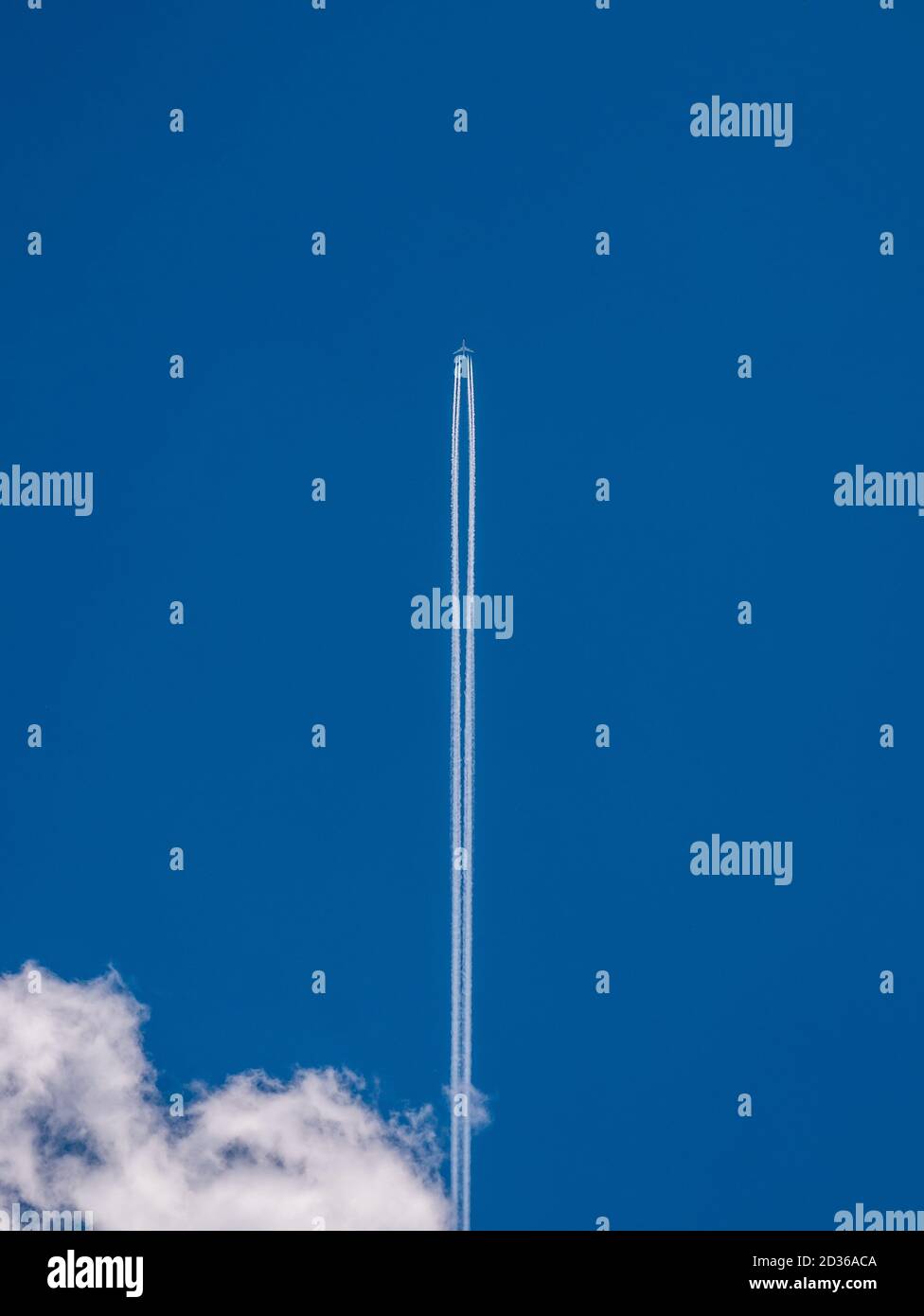 Flugzeug in den blauen Himmel mit einem Kondensstreifen und Eine Wolke in der linken unteren Ecke Stockfoto