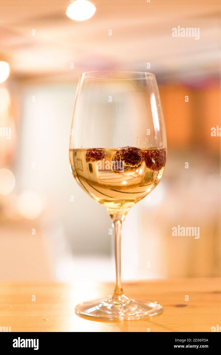 Ein Glas Lillet mit Himbeeren auf der Theke in Der Partykeller Stockfoto