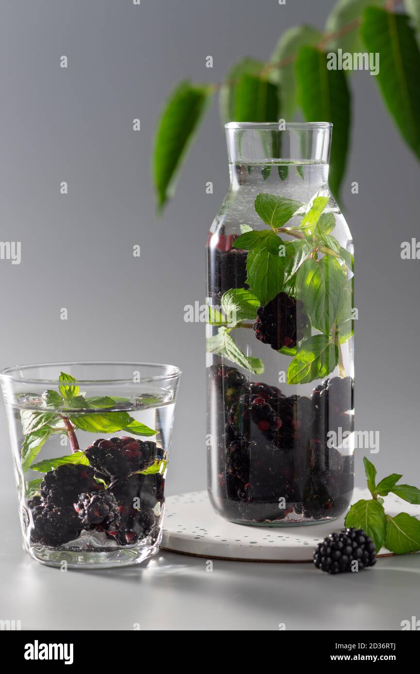 Glasflasche mit erfrischendem aromatisiertem Wasser mit Brombeeren und Minze Stockfoto