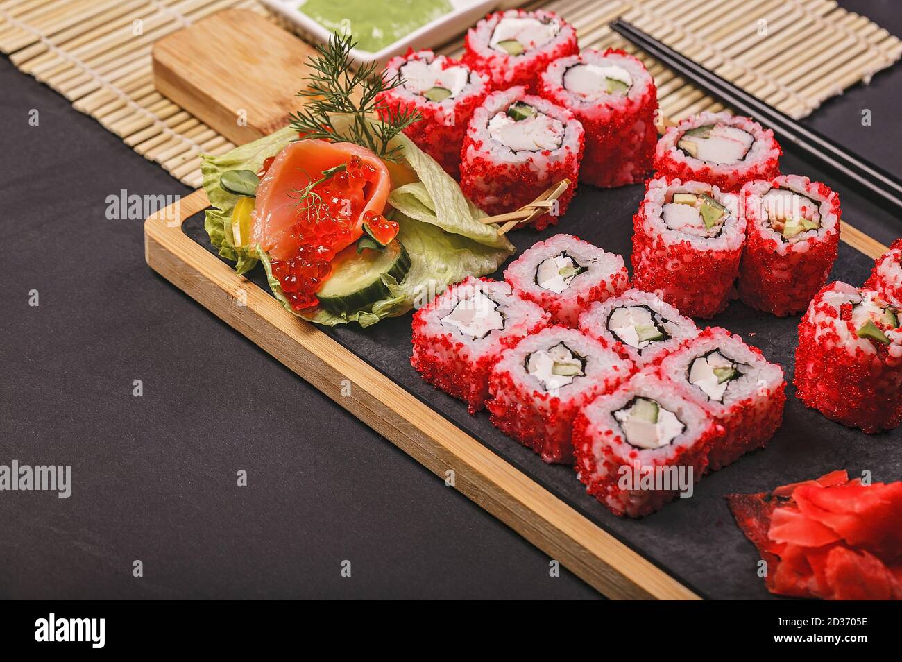 Japanisches Sushi-Roll-Set aus nächster Nähe mit rotem fliegendem Fischkaviar. Eingelegter Ingwer, würzige Wasabi-Paste und Sojasauce. Speicherplatz kopieren Stockfoto