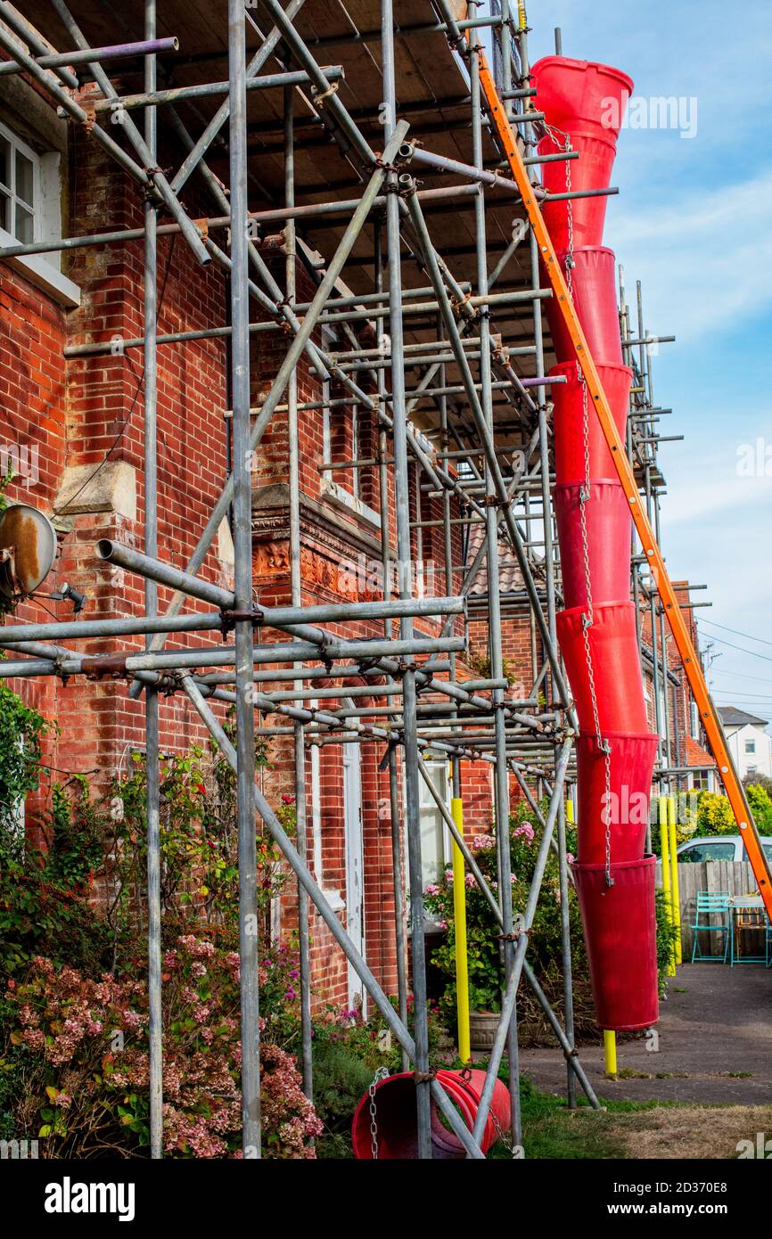 Gerüst und Müllrutsche an der Außenseite des Privathauses in Littlehampton, West Sussex Stockfoto