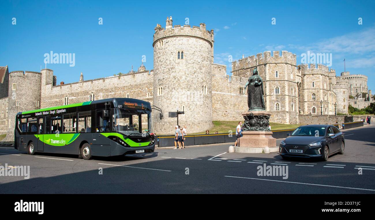 Windsor, Berkshire, England, Großbritannien. 2020. Verkehr vor Windsor Castle, ein Auto und lokaler Bus mit Queen Victoria auf einem Sockel. Ein schwarz-gelbes Painnt Stockfoto