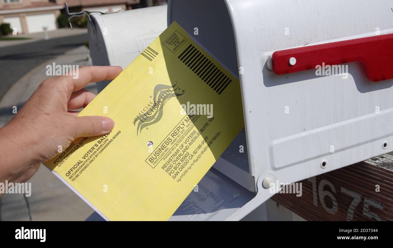 Nahaufnahme der Hand einer Frau, die ihren Briefwahlzettel zurückgibt und ihn in die Briefbox legt. Illustrative Editorial aufgenommen in Vista, CA / USA am 7. Oktober 2020. Stockfoto