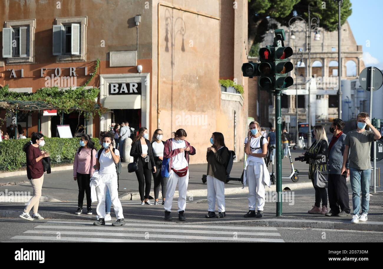 Rom, Italien. Oktober 2020. Menschen mit Gesichtsmasken warten darauf, in Rom, Italien, am 6. Oktober 2020 eine Straße zu überqueren. Fünf südliche Regionen Italiens haben verbindliche Maskengesetze eingeführt, auch für Menschen im Freien. Und die Regierung hat angekündigt, dass der nationale Ausnahmezustand, der am 31. Januar erstmals in Kraft gesetzt wurde, "zumindest" bis zu seinem einjährigen Jubiläum verlängert wird. Quelle: Cheng Tingting/Xinhua/Alamy Live News Stockfoto