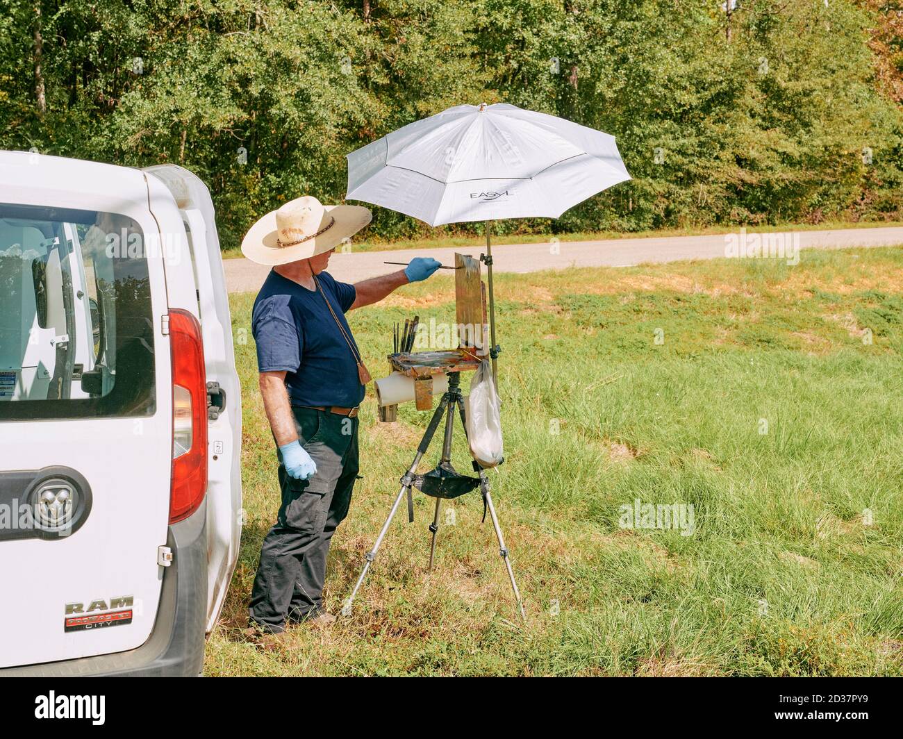 Mann oder Künstler malen eine Landschaft Szene mit einer Staffelei in Alabama, USA. Stockfoto