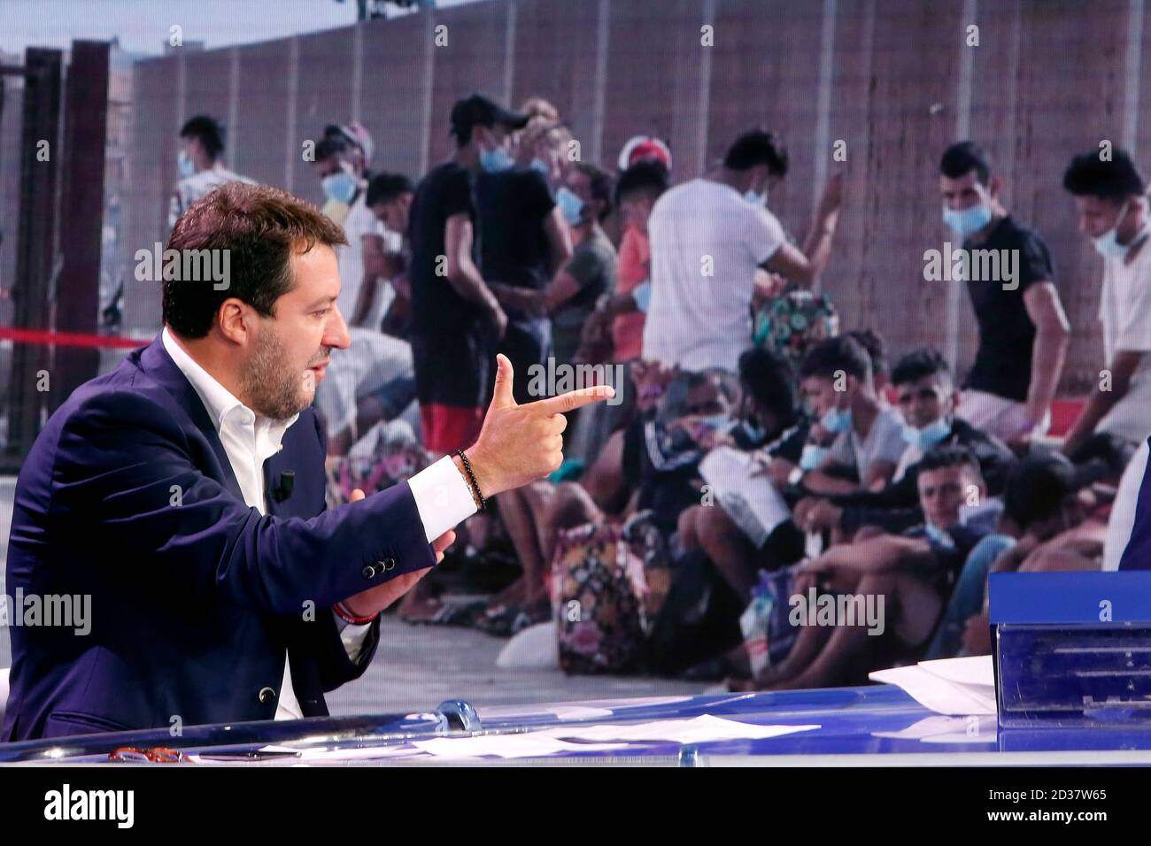 Rom, Italien. Oktober 2020. Der Sekretär der Lega rechten Partei Matteo Salvini macht das Singen einer Waffe und im Hintergrund, auf dem Bildschirm, ein Foto von Migranten während der tv-Show Porta a Porta. Rom (Italien), 7. Oktober 2020 Foto Samantha Zucchi Insidefoto Kredit: Insidefoto srl/Alamy Live News Stockfoto