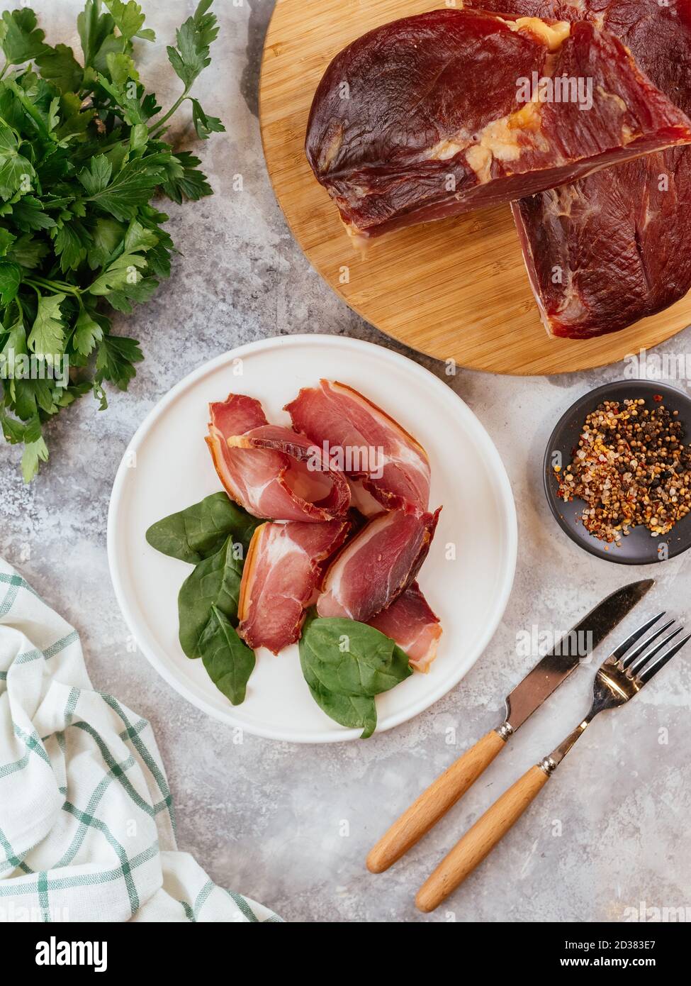 Pastrami in Scheiben geschnitten auf einem Teller mit Kräutern Stockfoto